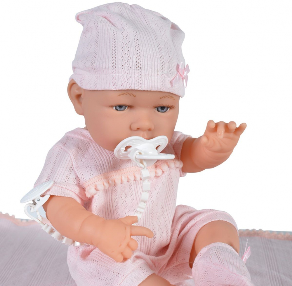 Papusa Bebelus 41cm Moni Baby Girl Pink, cu salopeta tricotata, caciulita, paturica de infasat si suzeta